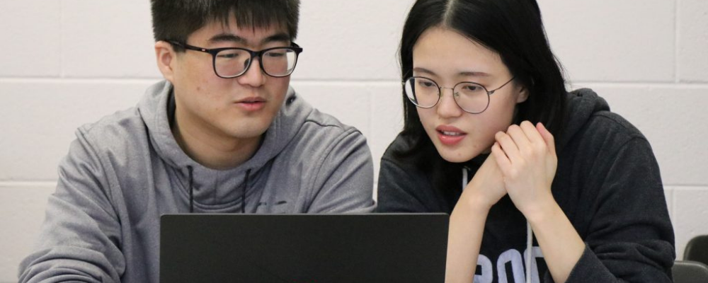 Image of 2 students looking at computer